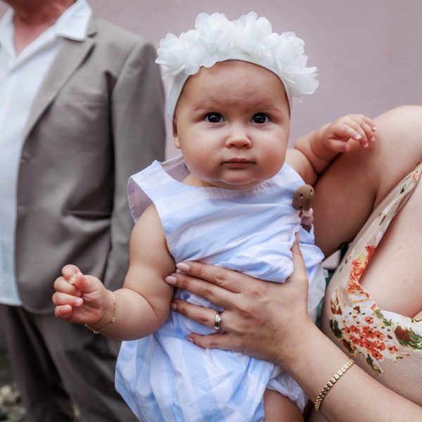Michaelskirche, Pfinztal-Söllingen Baby mit weißem Blumen-Haarband auf dem Arm – Michaelskirche, Pfinztal-Söllingen