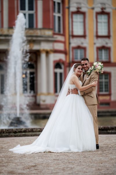 Schlosspark Bruchsal Brautpaar umarmt sich vor einem Springbrunnen an Schloss Bruchsal – Schlosspark Bruchsal