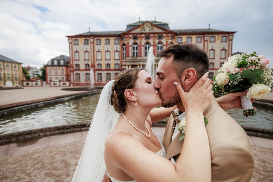 Schlosspark Bruchsal Brautpaar küsst sich vor Schloss Bruchsal am Brunnen – Schlosspark Bruchsal