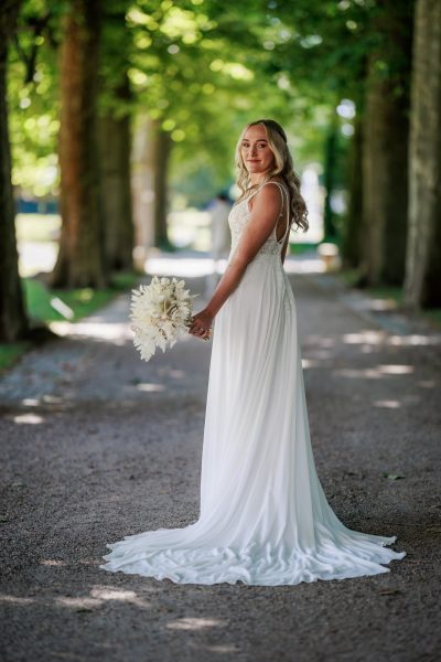Schlosspark Eichtersheim, Angelbachtal Braut steht mit Brautstrauß in einer schattigen Allee im Schlosspark Eichtersheim – Schlosspark Eichtersheim, Angelbachtal