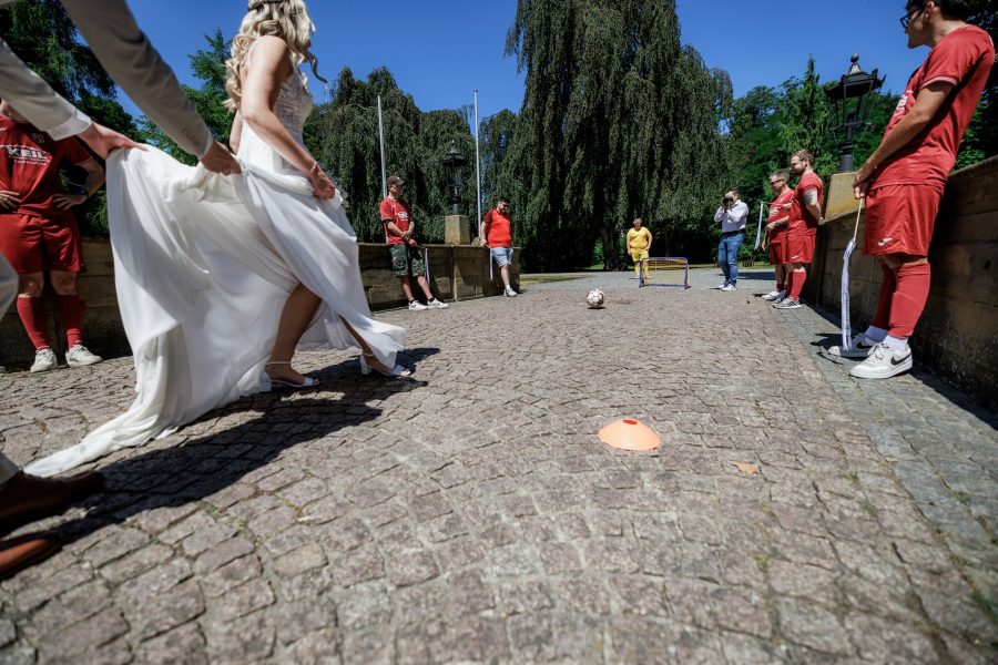 Schlosspark Eichtersheim, Angelbachtal Braut schießt einen Fußball, eine Fußballmannschaft in roten Trikots schaut zu – Schlosspark Eichtersheim, Angelbachtal