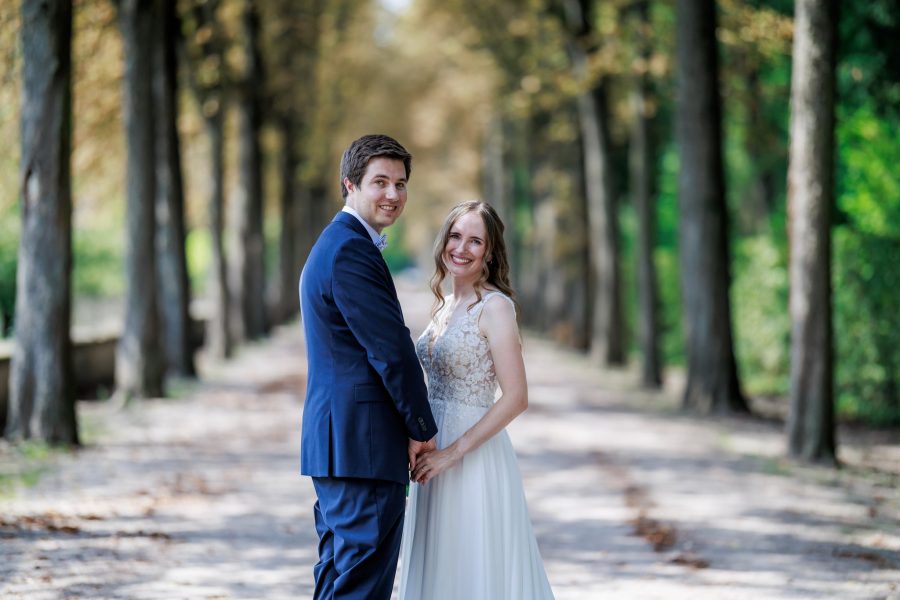 Schlossgarten Schwetzingen Brautpaar steht Hand in Hand in einer Allee im Schlossgarten Schwetzingen – Schlossgarten Schwetzingen