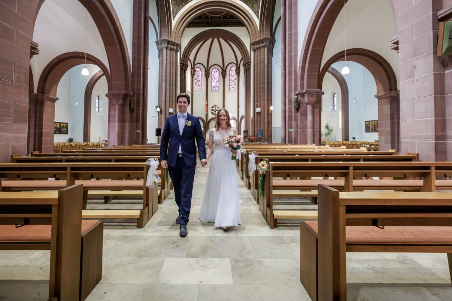 St. Bonifatius, Heidelberg-Weststadt Brautpaar verlässt Hand in Hand die Kirche durch den Mittelgang – St. Bonifatius, Heidelberg-Weststadt