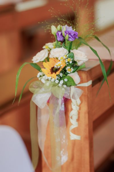 Blumenschmuck mit Sonnenblume an der Kirchenbank