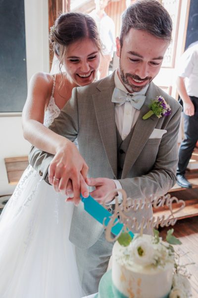 Landgut Lingental, Leimen Das Brautpaar schneidet lachend die Hochzeitstorte an – Landgut Lingental, Leimen